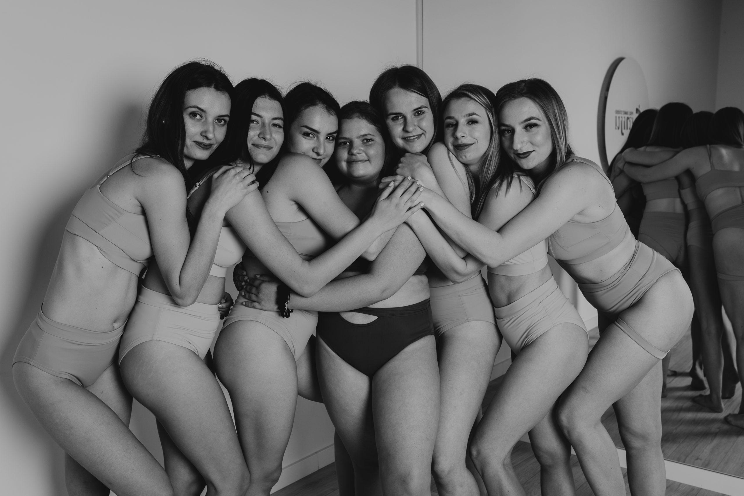 Dziewczyny stojące przodem do obiektywu i wtulone w siebie do grupowego zdjęcia