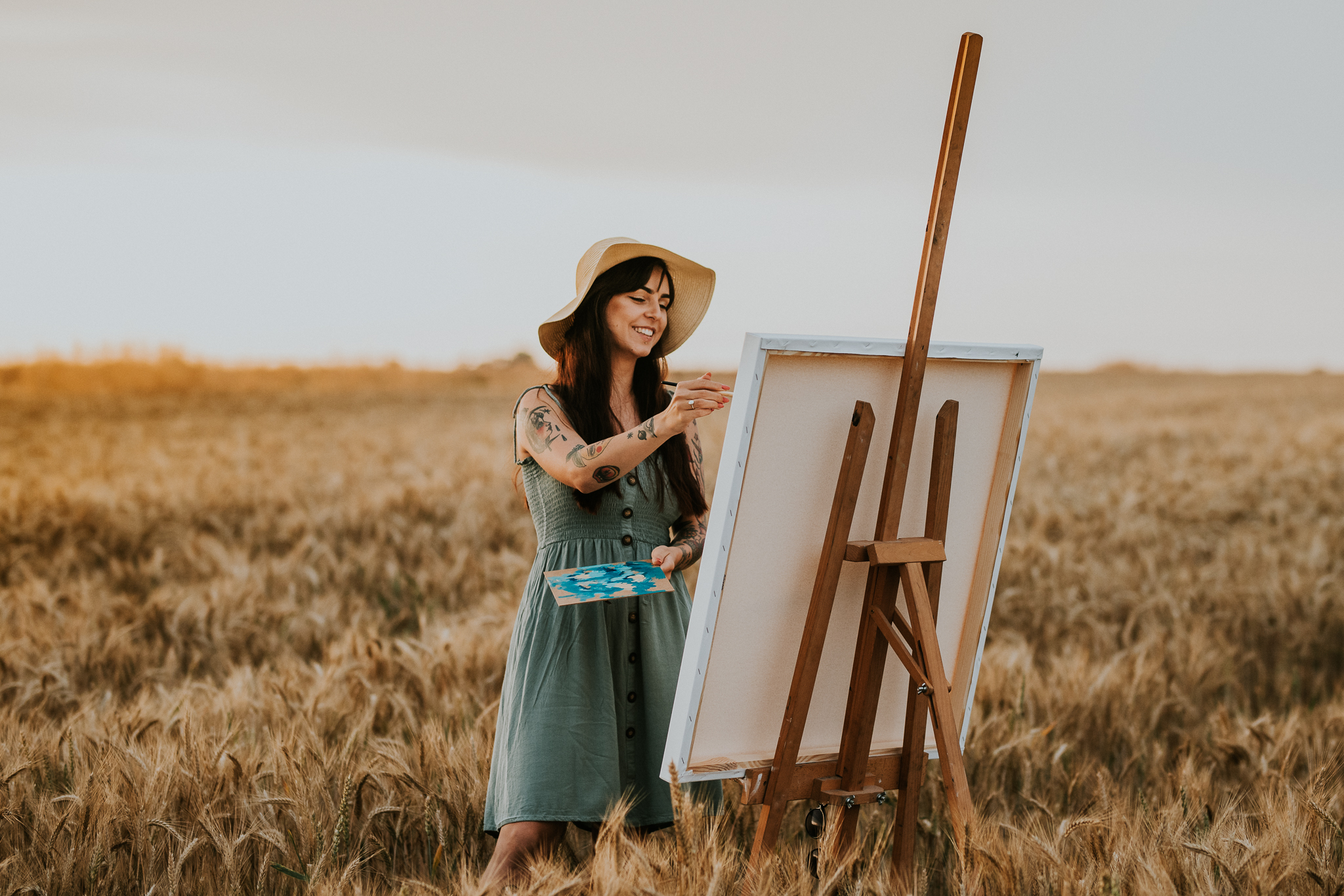 Kobieta maluje na sztaludze, stoi w zbożu