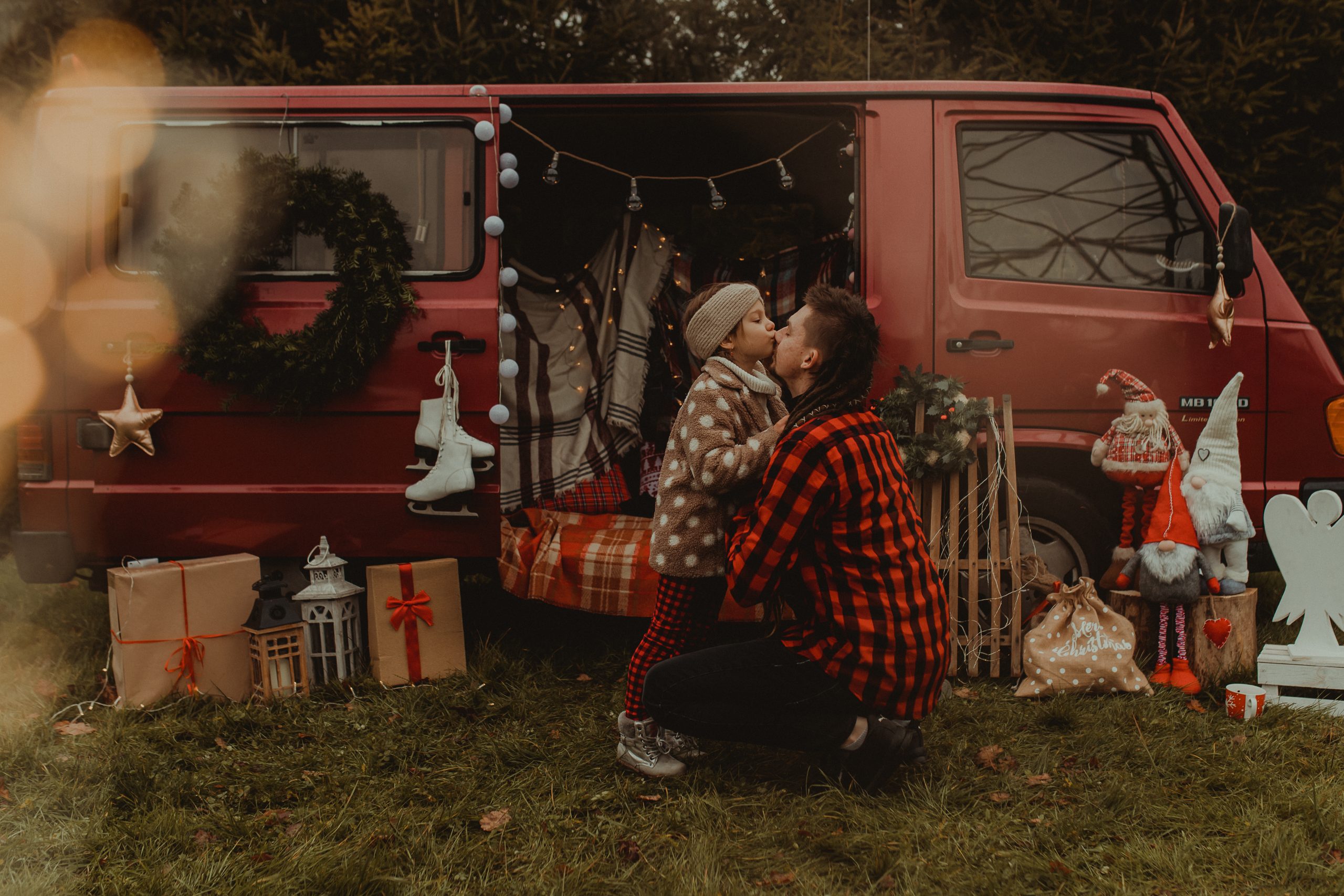 Dziewczynka całuje tatę w nos przed świątecznym busem