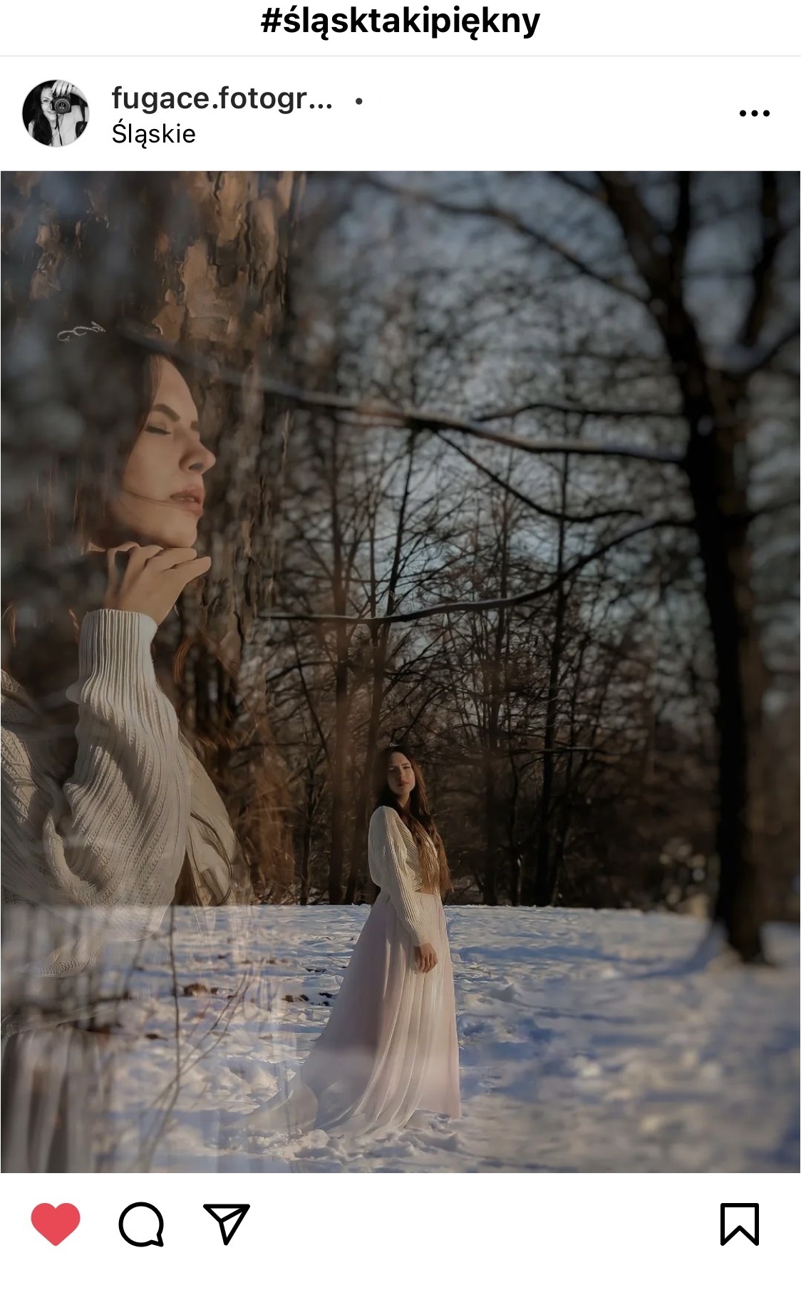 Kobieta w białej kurtce i pięknych długich włosach stojąca w śniegu w lesie.