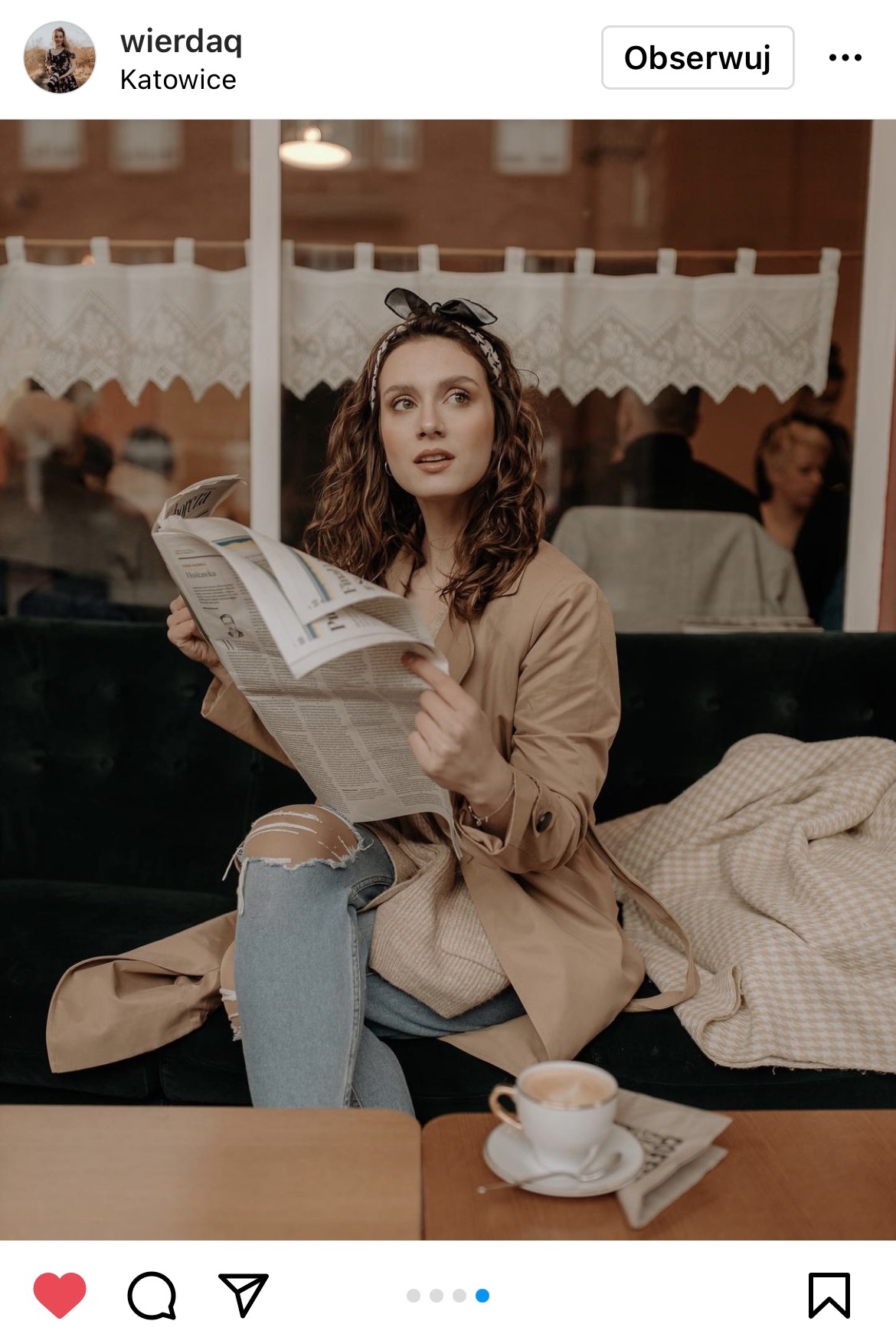 brunetka siedząca na sofie i czytająca gazetę