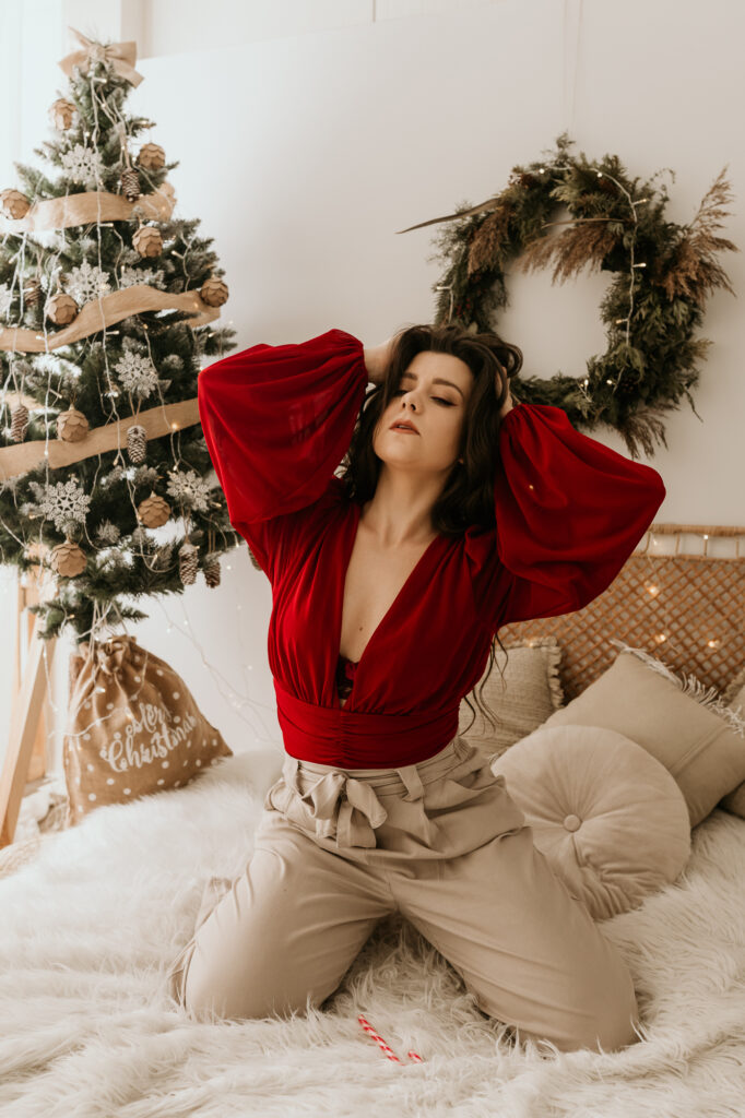 kobieta pozująca klęcząca na łóżku w świątecznej stylizacji