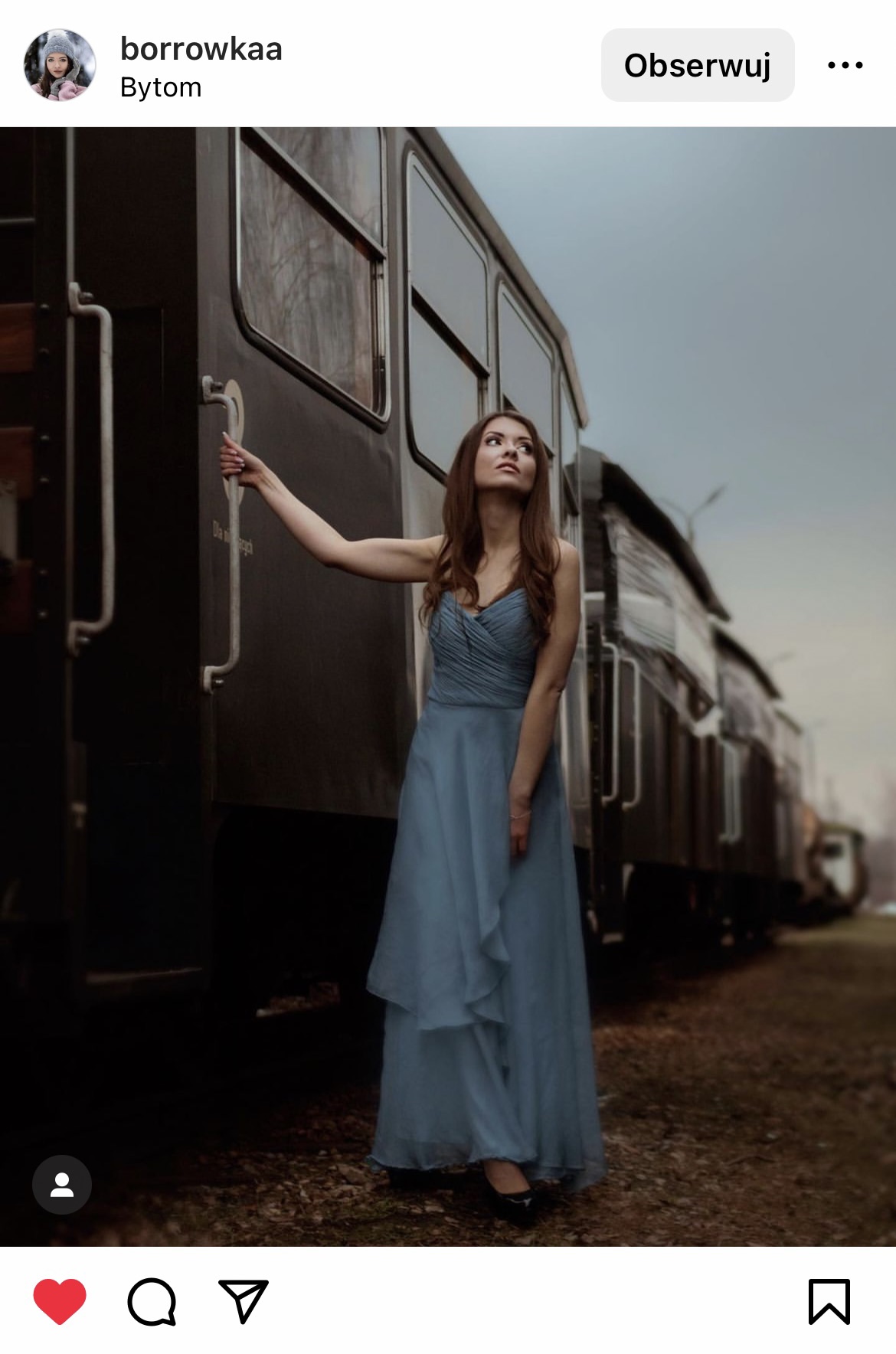 Kobieta w niebieskiej sukience trzymająca się wejścia do starego czarnego wagonu pociągu #śląsktakipiękny