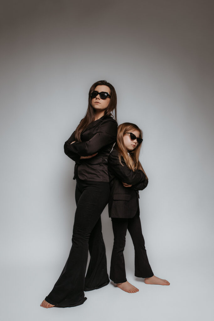 matka i córka stoją oparte do siebie plecami mają tę samą stylizację