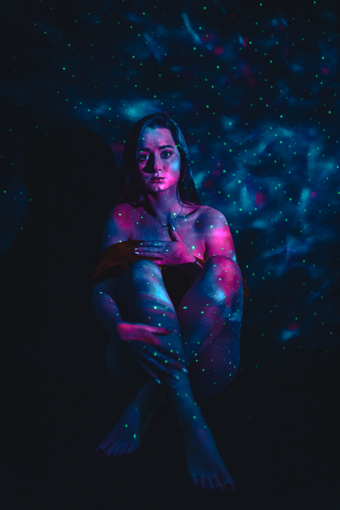 Kobieta skąpana w kolorach sztucznego światła. Sesja zmysłowa
