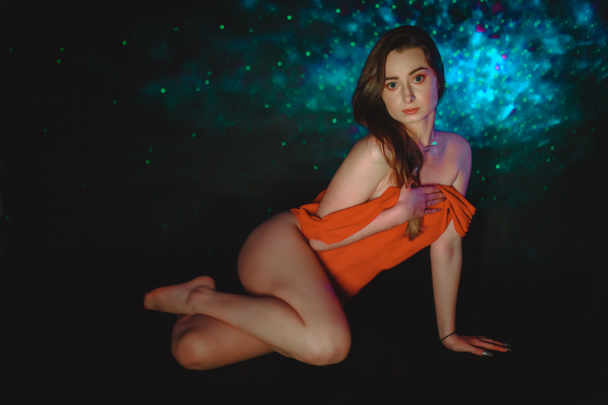 Kobieta pozująca na podłodze do aparatu. Sesja zmysłowa