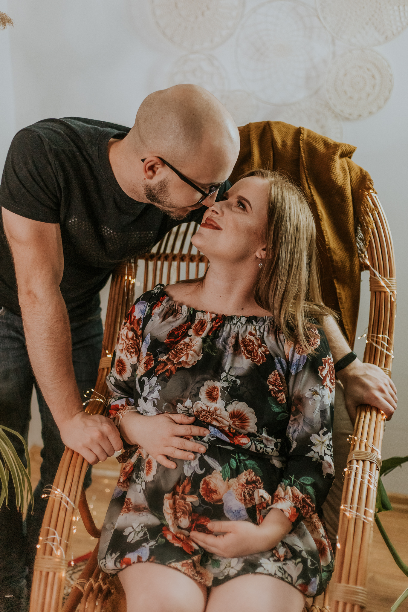 Przyszły tata patrzy w oczy przyszłej mamie, która siedzi na fotelu bujanym