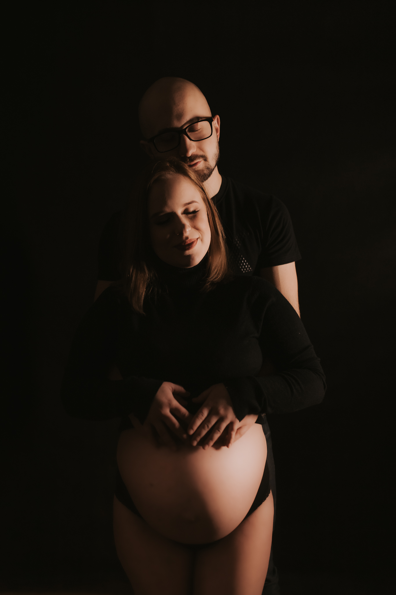 Para rodziców wtulona trzymająca się za brzuch