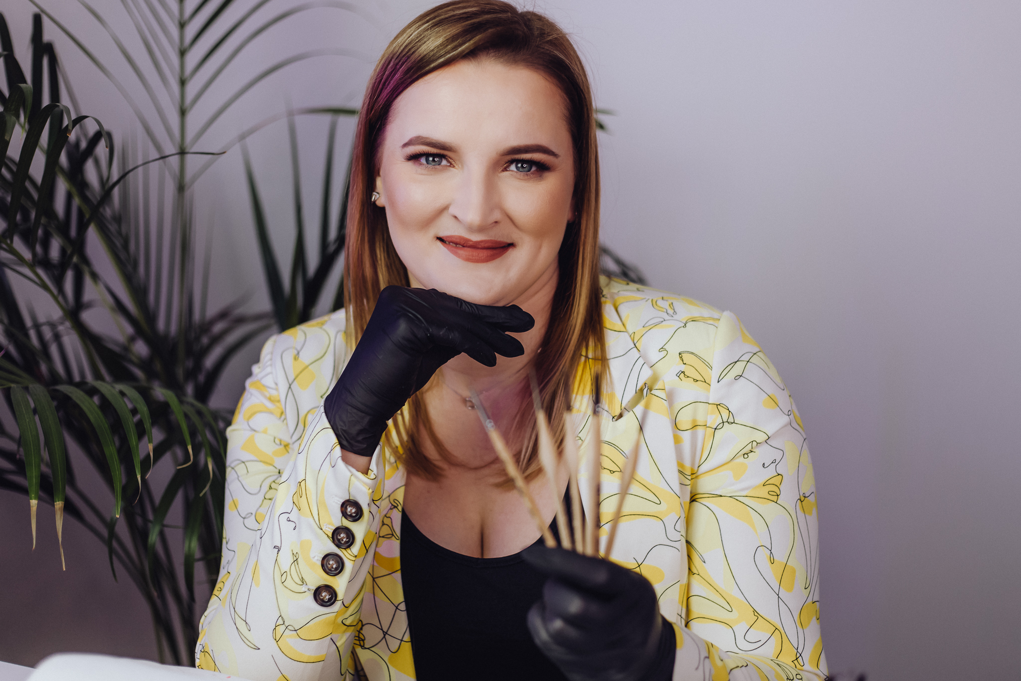 Uśmiechnięta kosmetyczka w rękach trzyma pędzelki