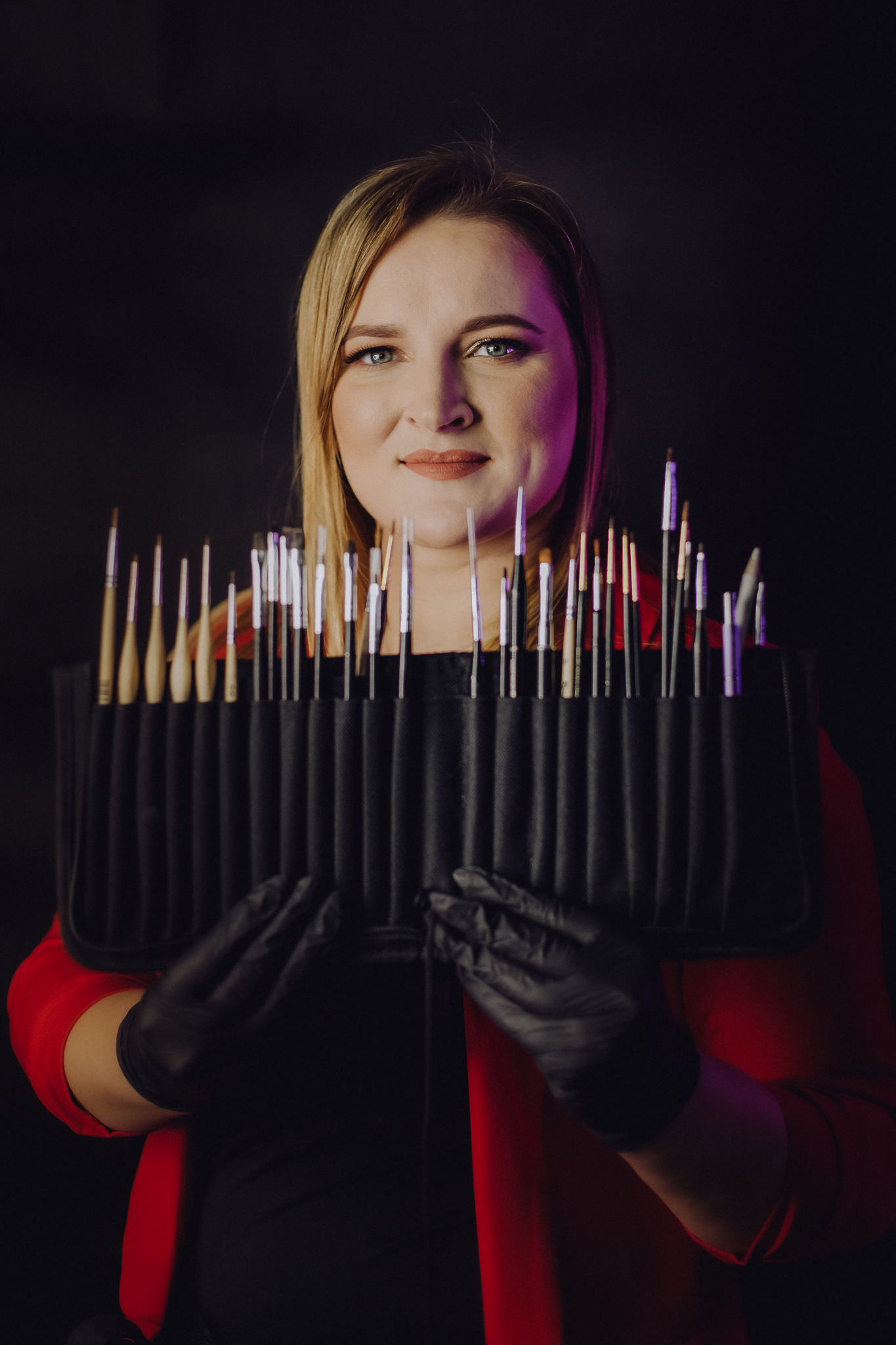 Kobieta, która trzyma w rękach zestaw pędzi do malowania