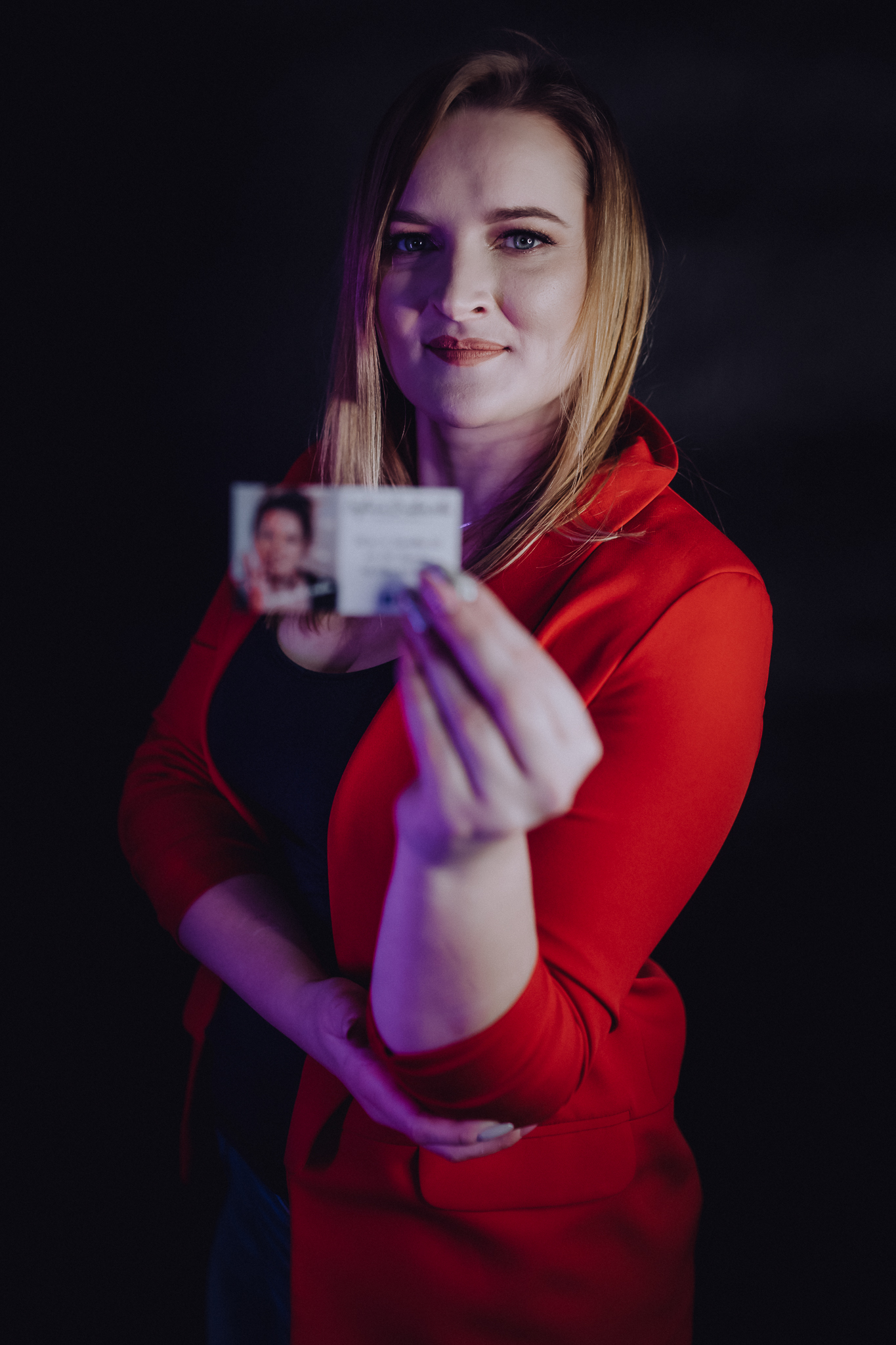 Kobieta pozuje z wizytówką swojego biznesu