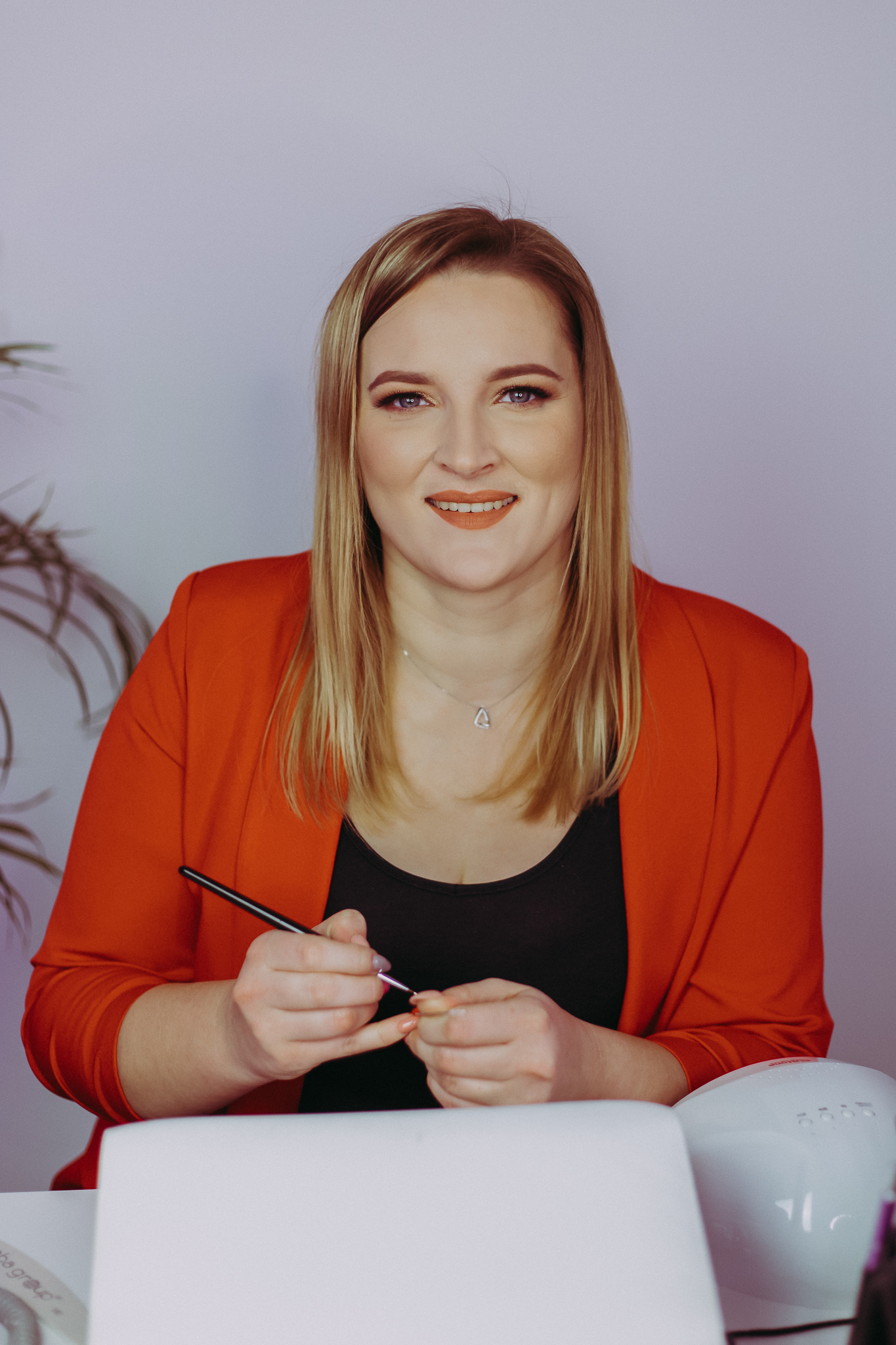 Uśmiechnięta blondynka przy lampie do paznokci. Sesja wizerunkowa