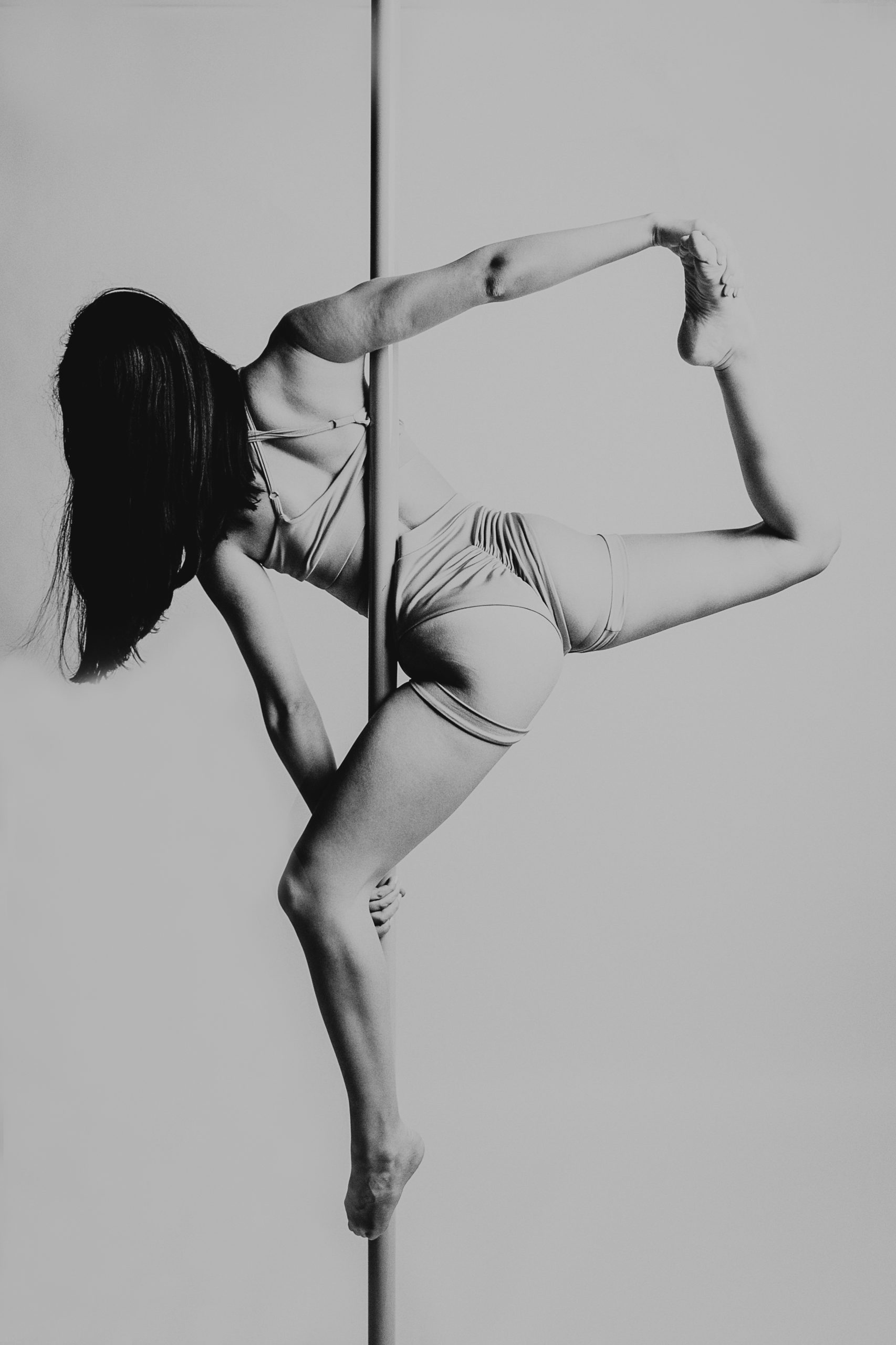 Dziewczyna pomiędzy której ciałem jest rura do pole dance