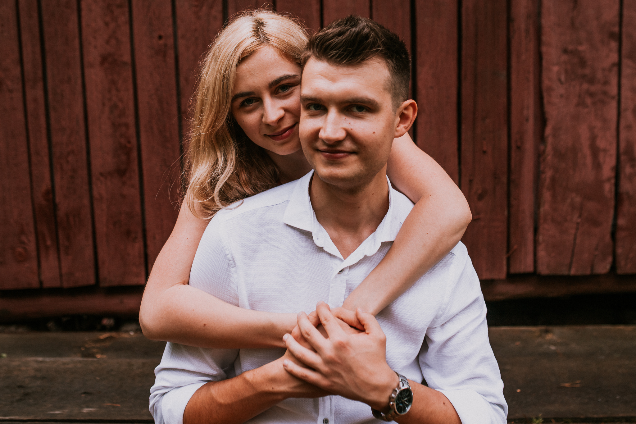 Uśmiechnięta kobieta przytula mężczyznę od tyłu