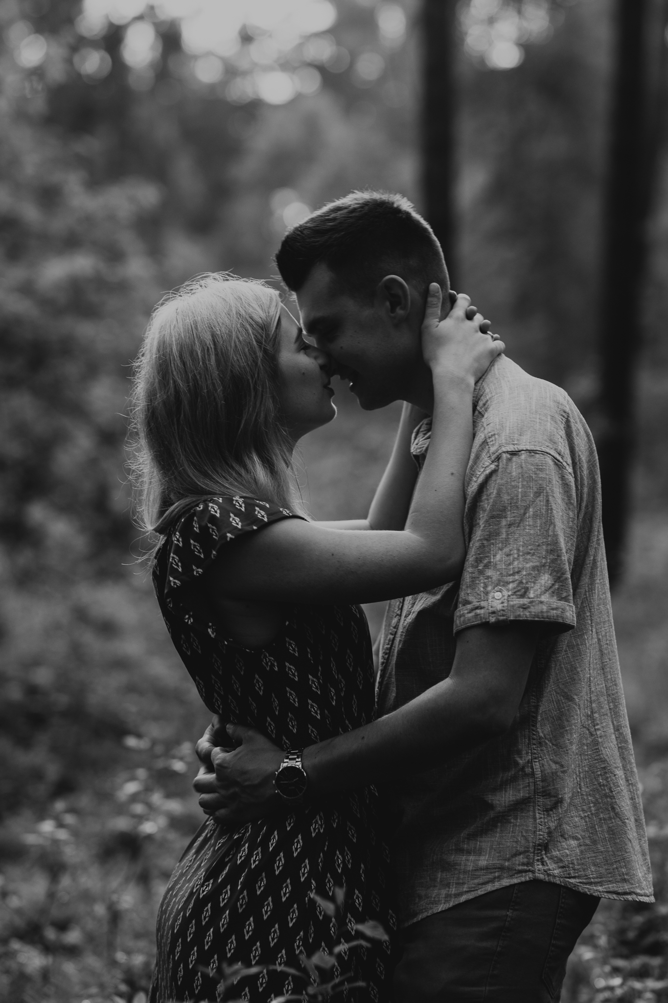 Dziewczyna całuje chłopaka. Sesja narzeczeńska w plenerze