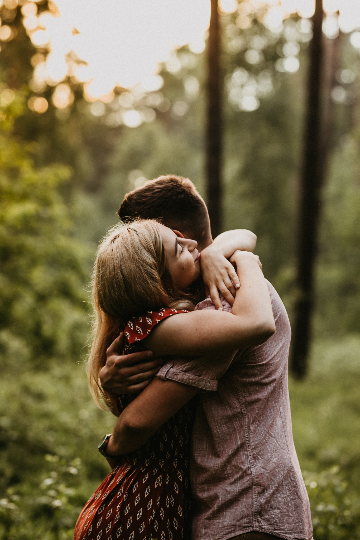 Dziewczyna mocno tuli się do chłopaka. W tle las