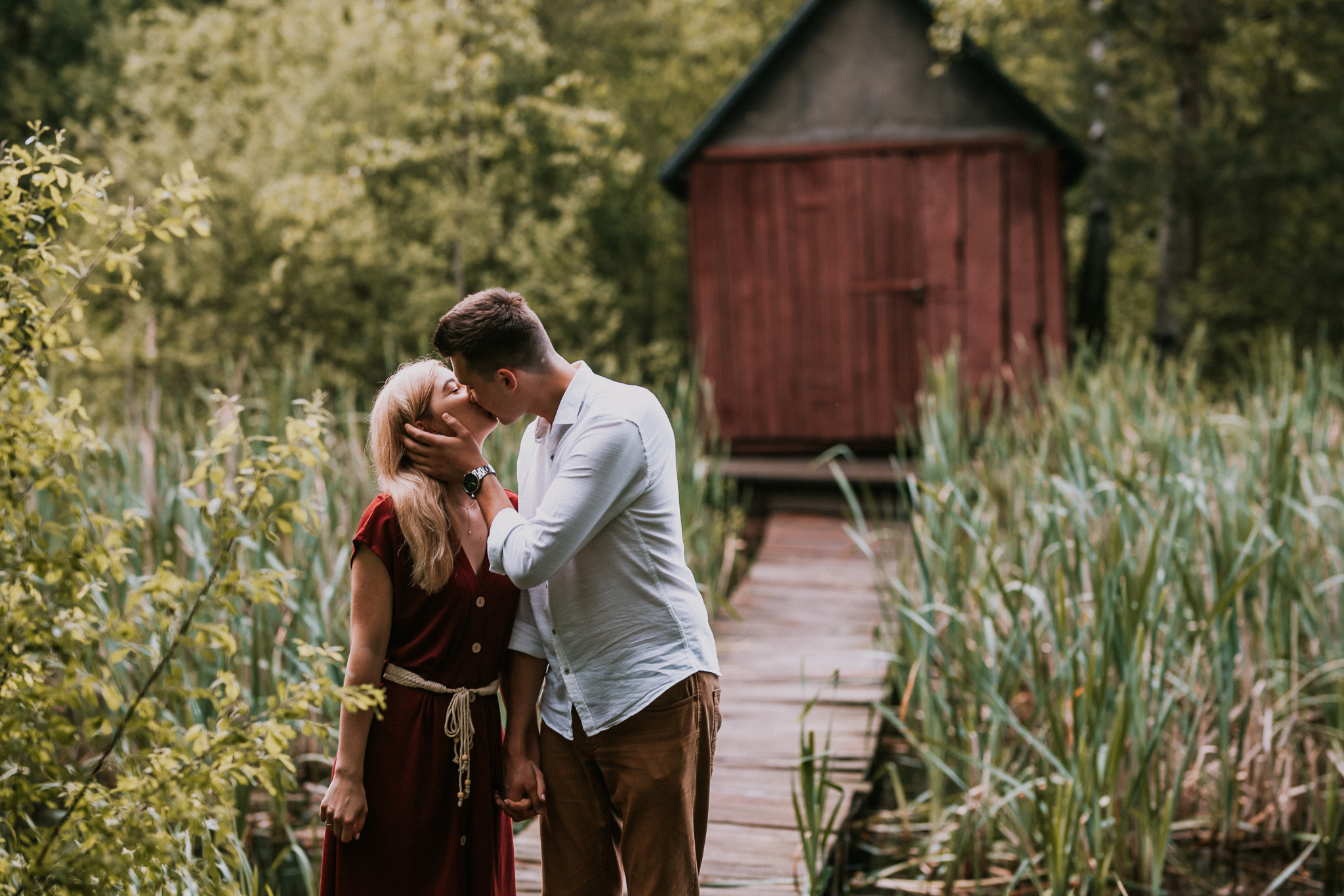 Para całująca się w tle domek drewniany i tatarak