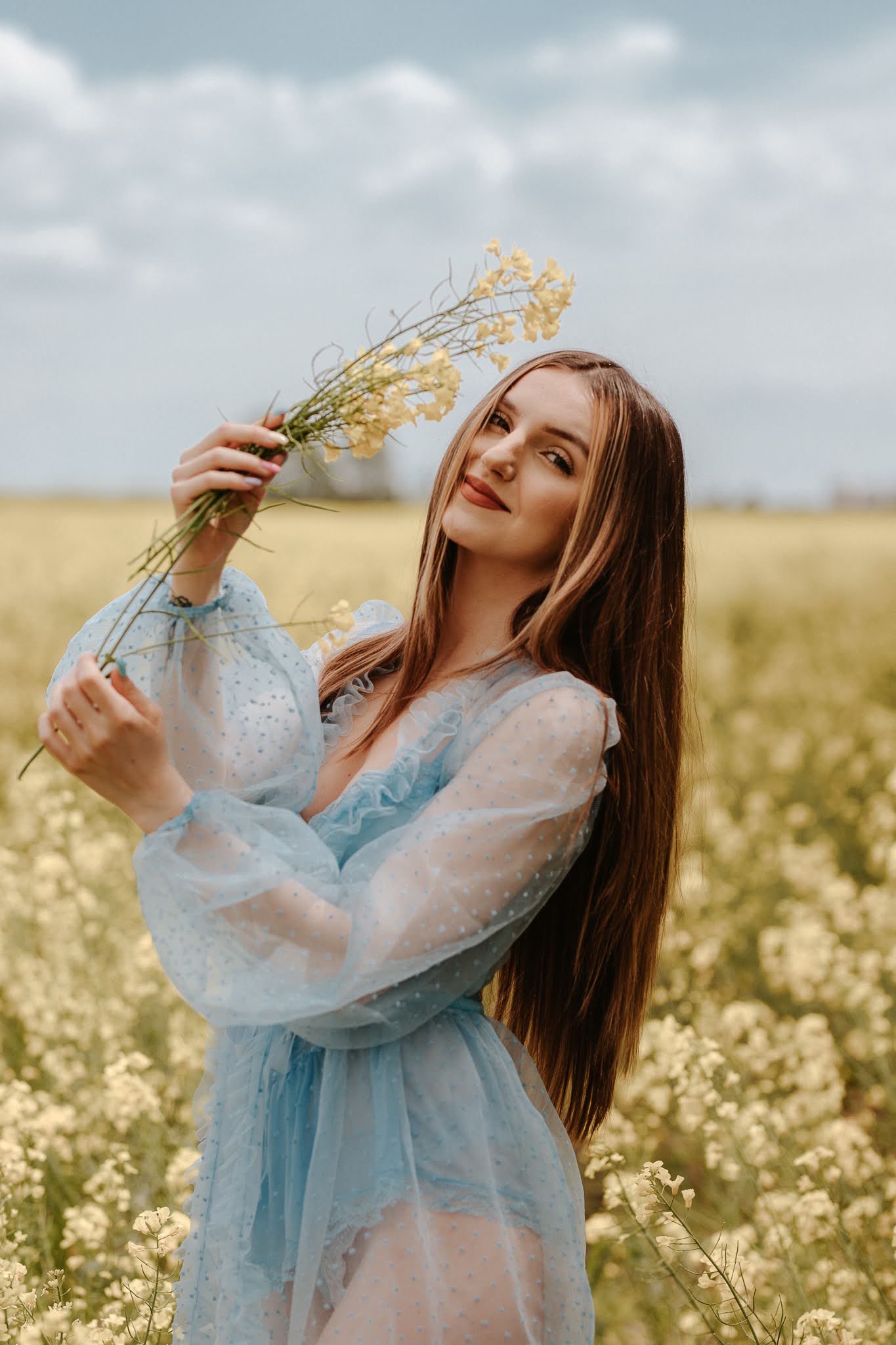 Dzrewczyna w ręce trzyma gałązkę rzepaku