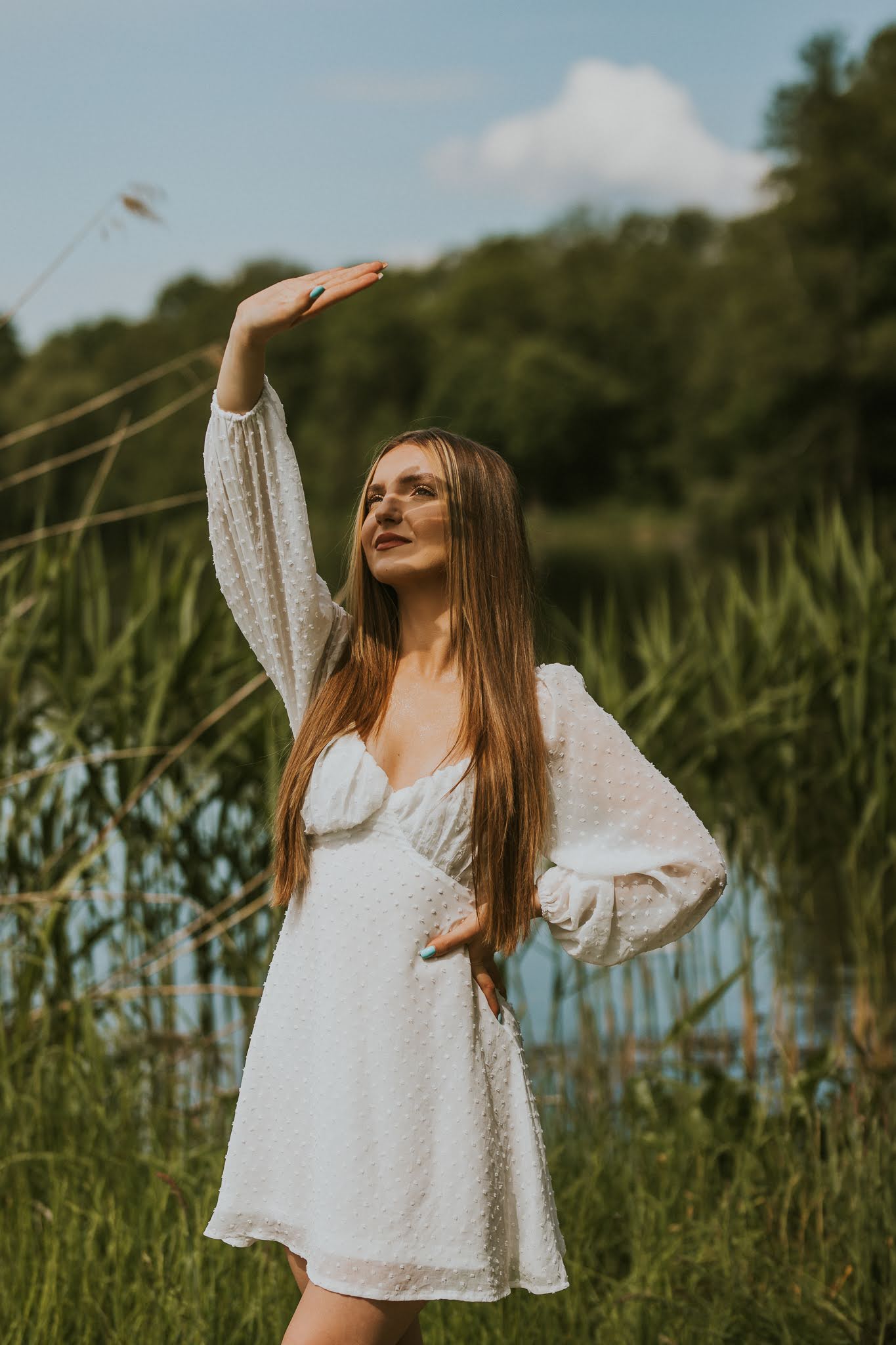 Dziewczyna zakrywa wyciągniętą ręką słońce