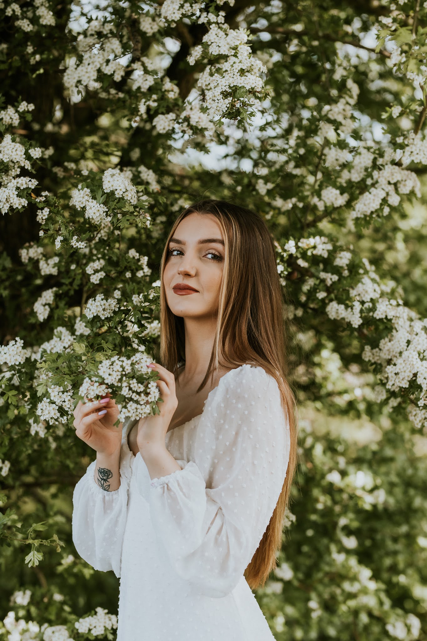 Nieskazitelna uroda dziewczęca w dłoni trzyma gałązkę kwitnącego drzewa