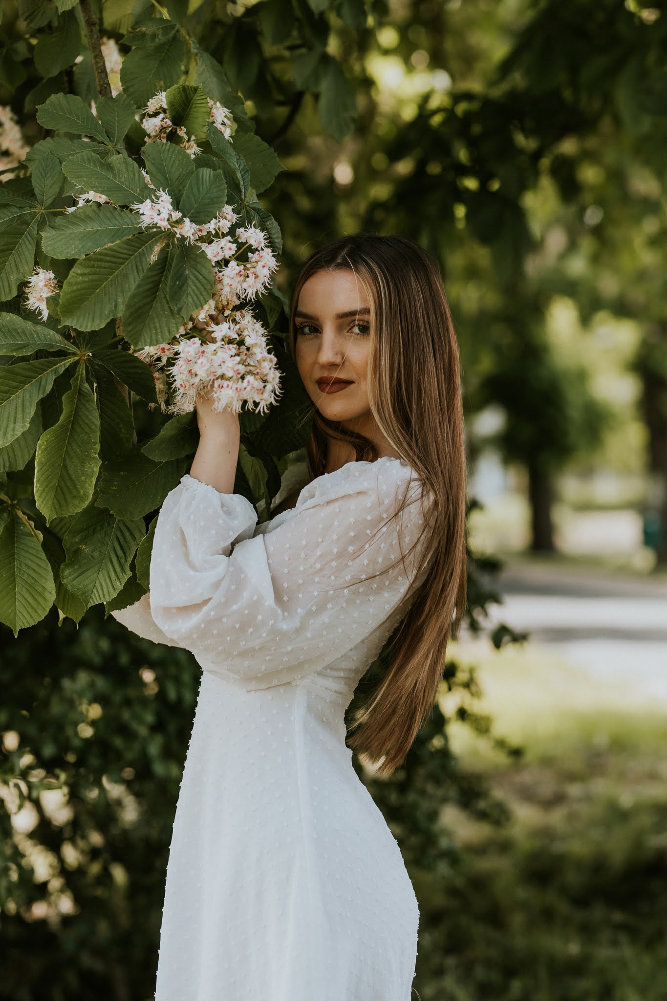 Młoda dziewczyna wtulona w kwitnące drzewi