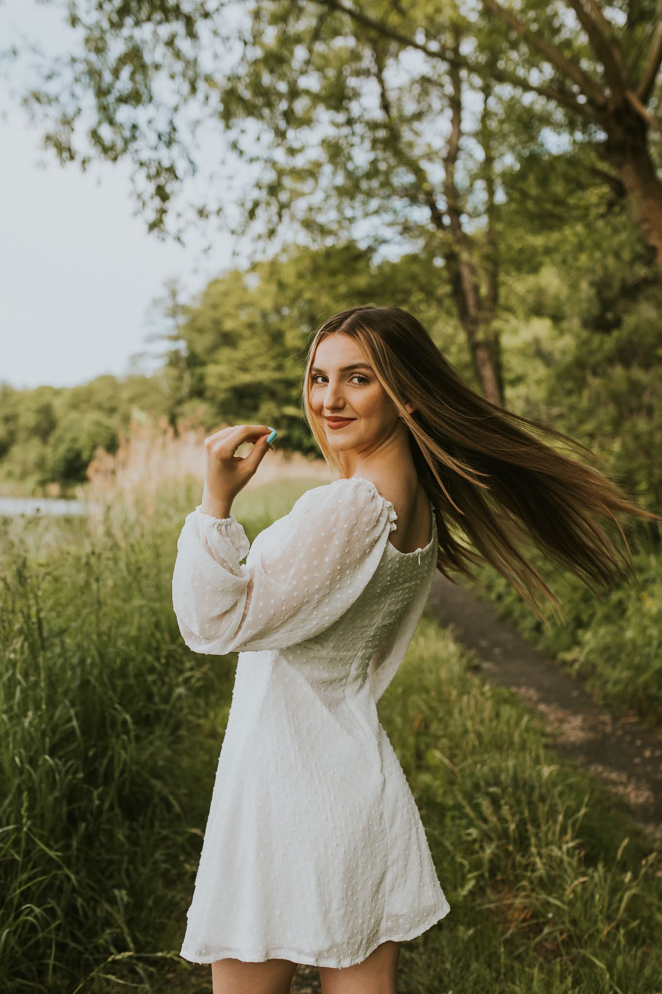 Dziewczyna w rozczochranych długich włosach z lewą ręką w górze