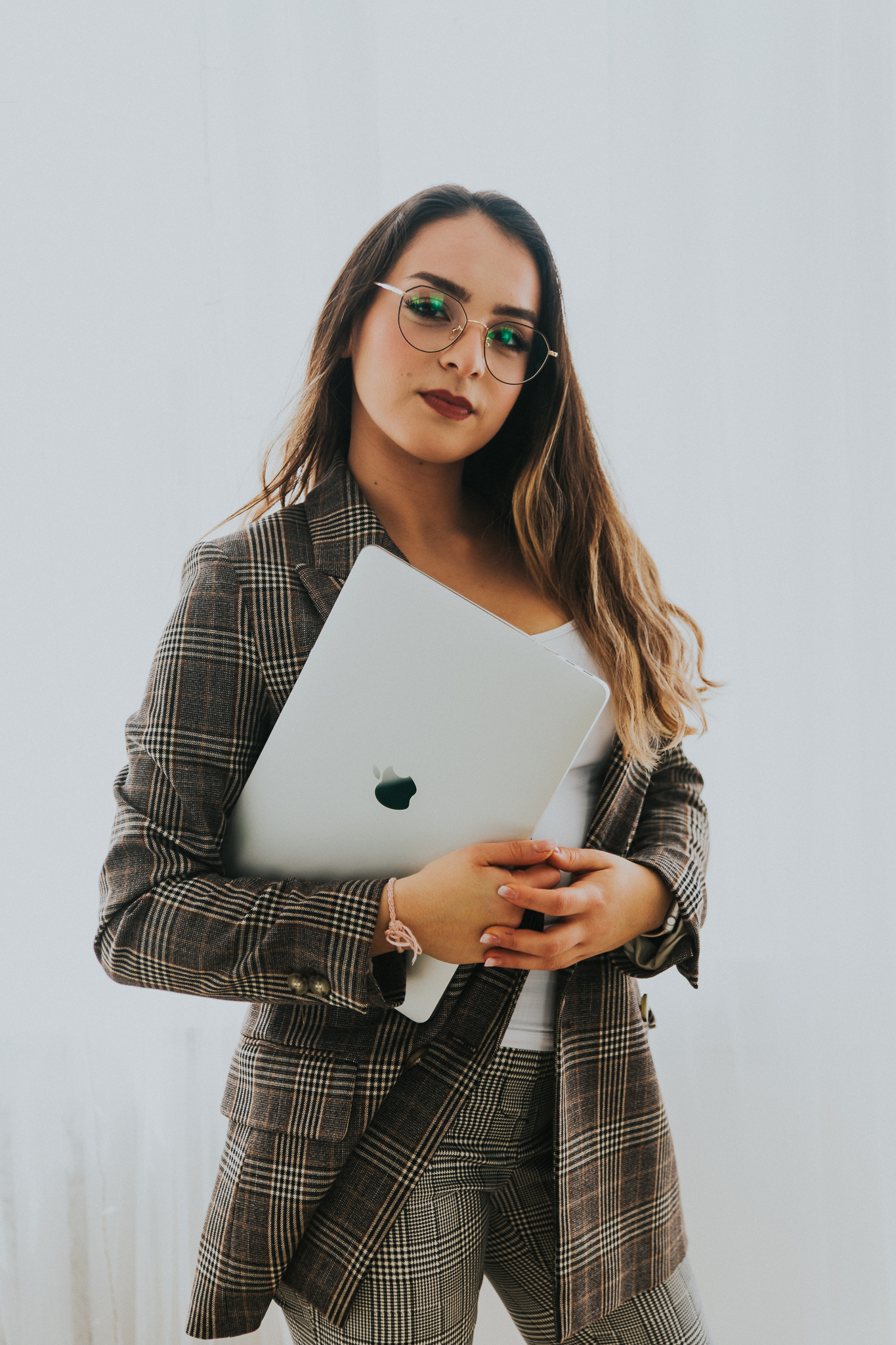 Kobieta elegancka w żakiecie, trzyma laptop w rękach