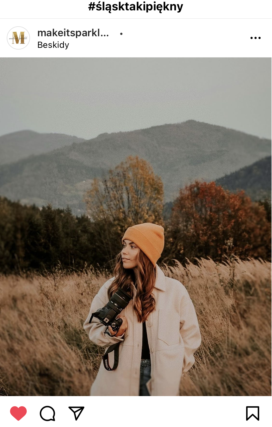 Młoda kobieta na tle gór, w rękach ma aparat