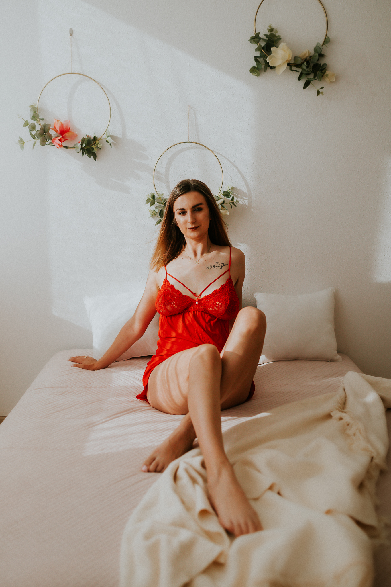 Kobieta w czerwonej halce siedząca na łóżku