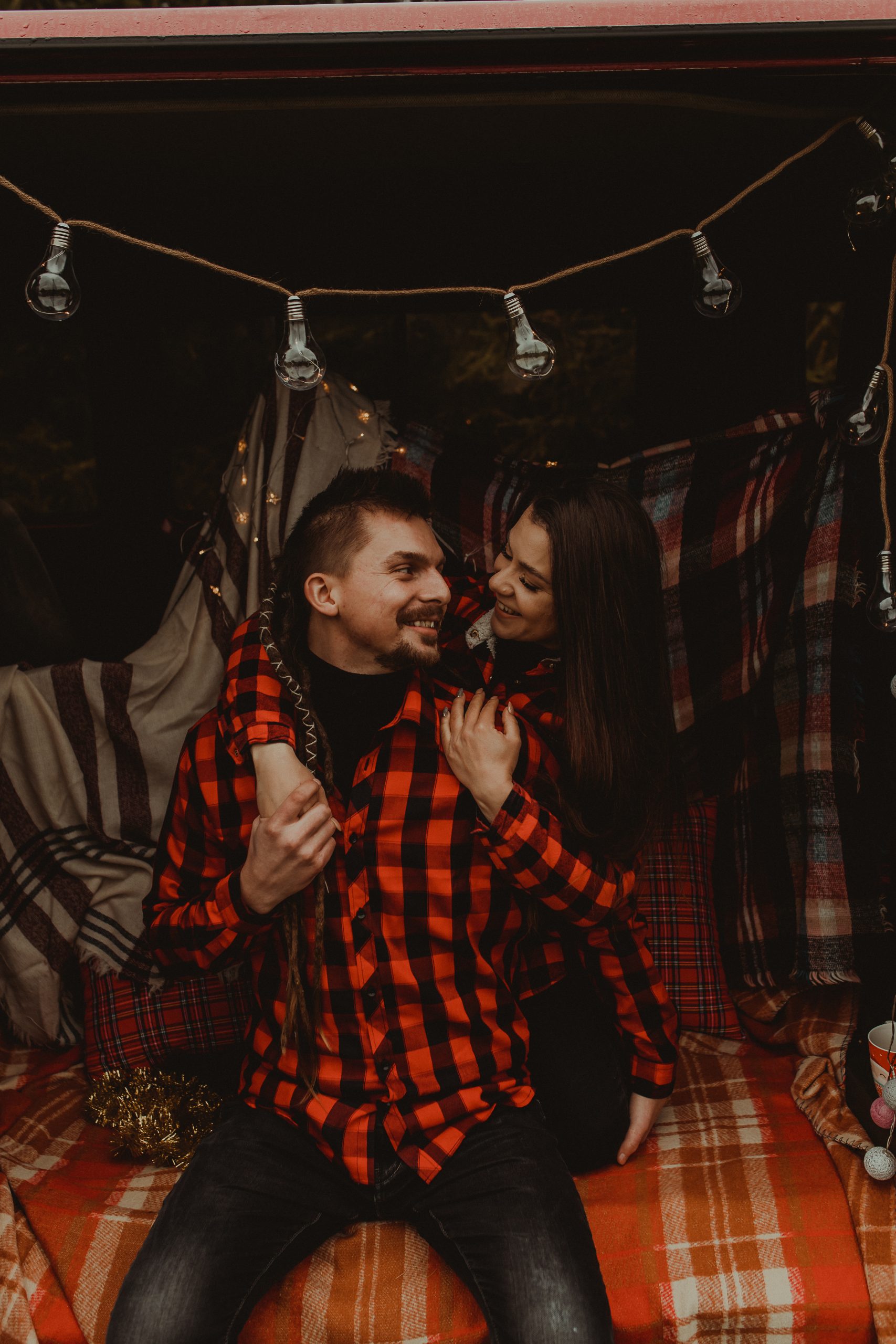 Para siedzi wewnątrz busa. Są przytuleni i wpatrują się w siebie jak w obraz