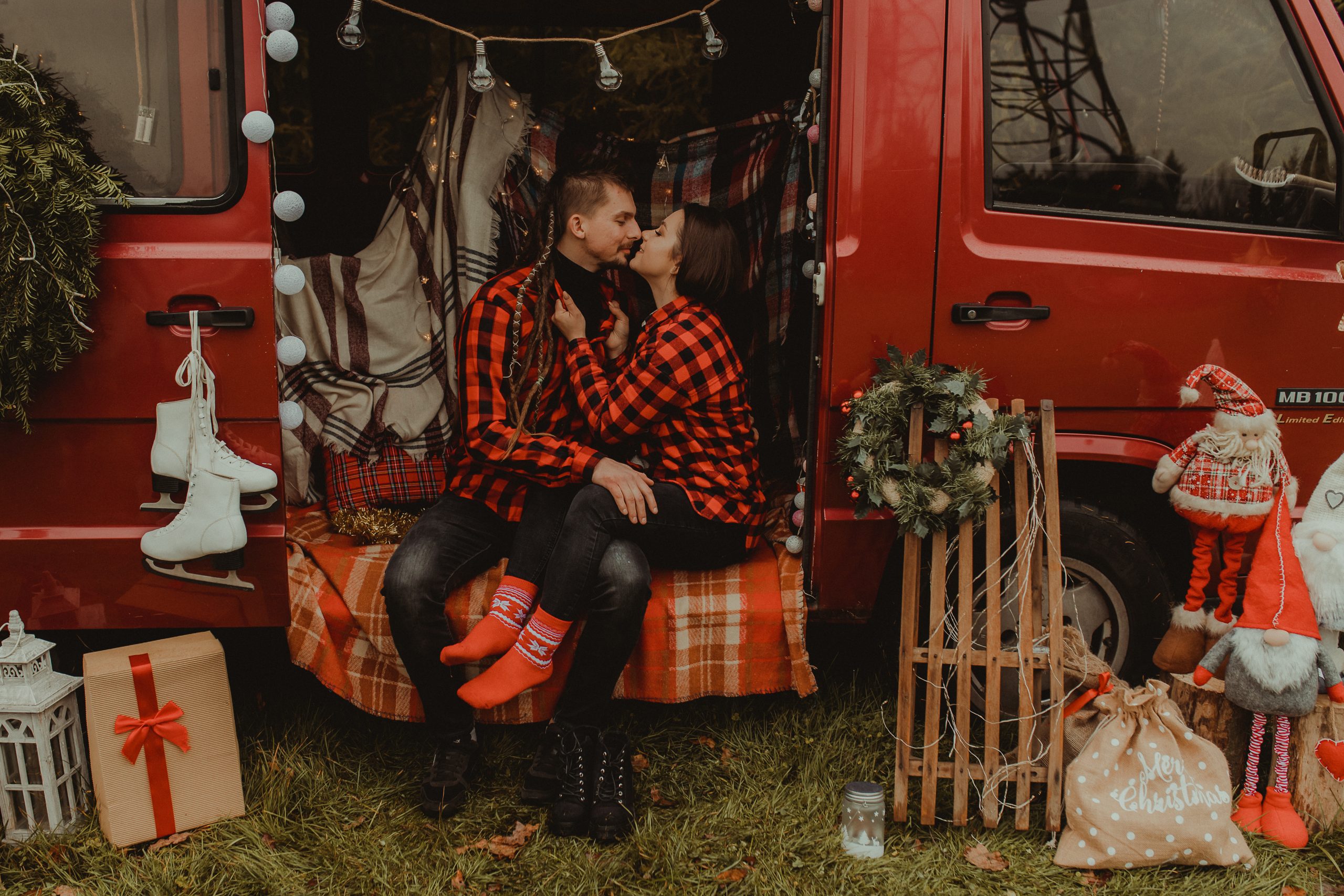 Całująca się para w busie. Obok stoją sanki. Kobieta ma czerwone skarpety