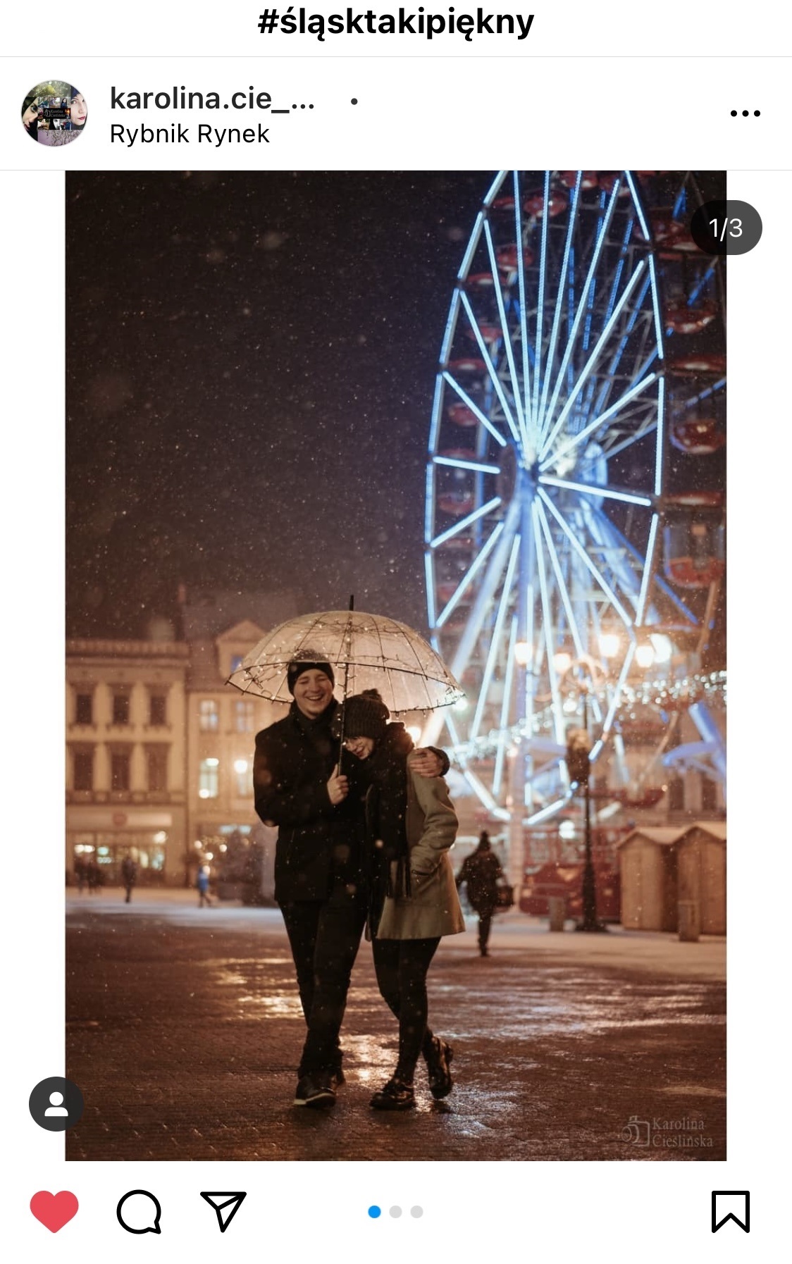 Para pod parasolką. W tle oświetlone Diabelskie Koło.