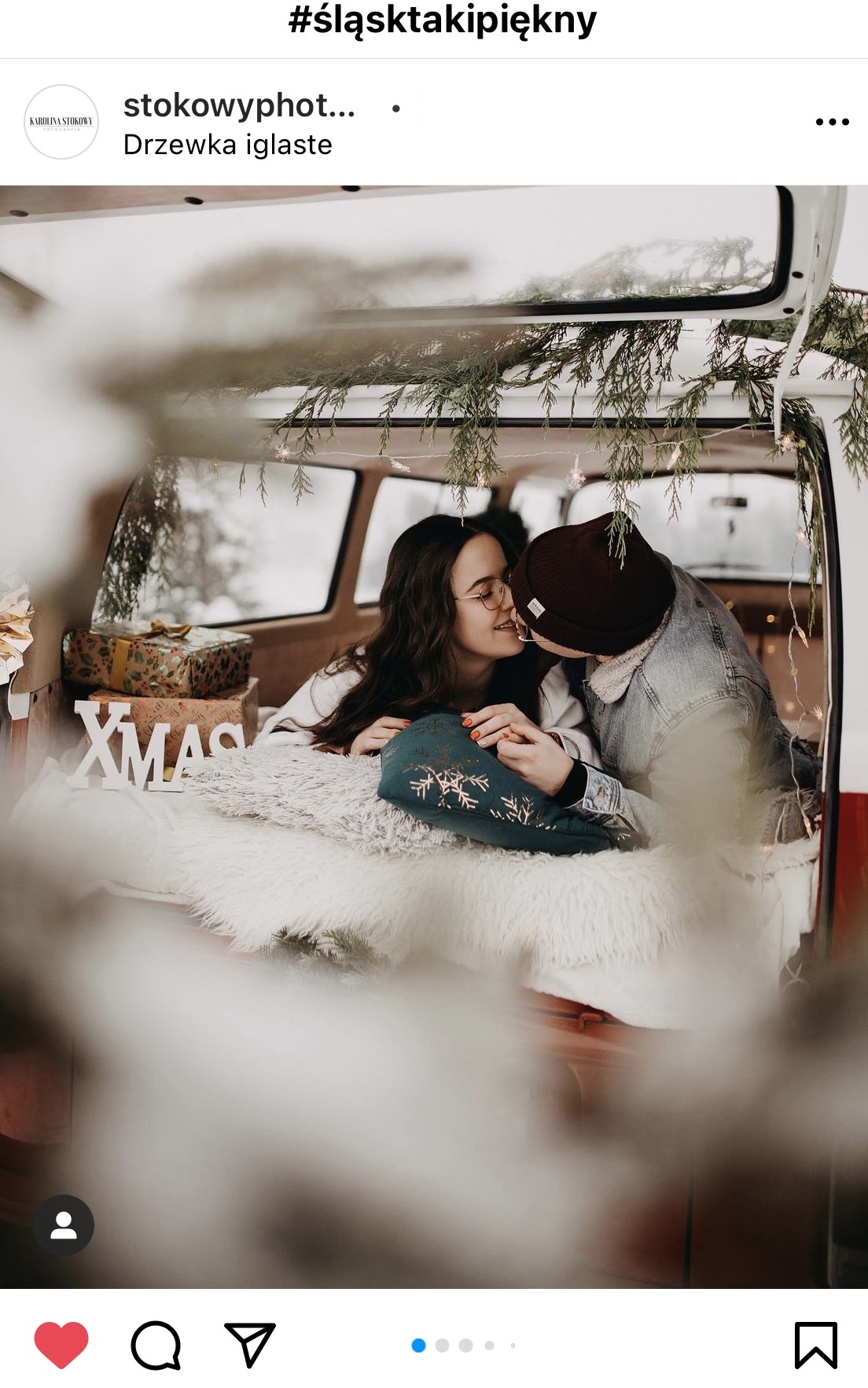 Para zimowo ubrana całuje się w bagażniku samochodu.