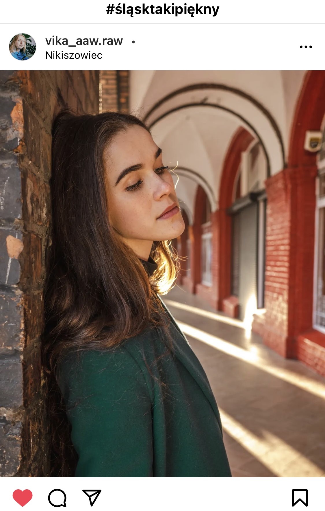 Dziewczyna oparta o mur. W tle ceglaste łuki.