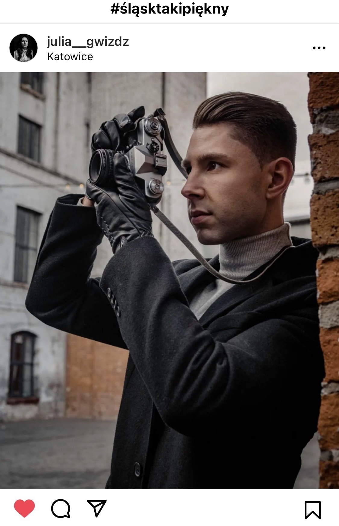 Mężczyzna elegancko ubrany w ręku trzyma aparat. W tle kamienice. #śląsktakipiękny