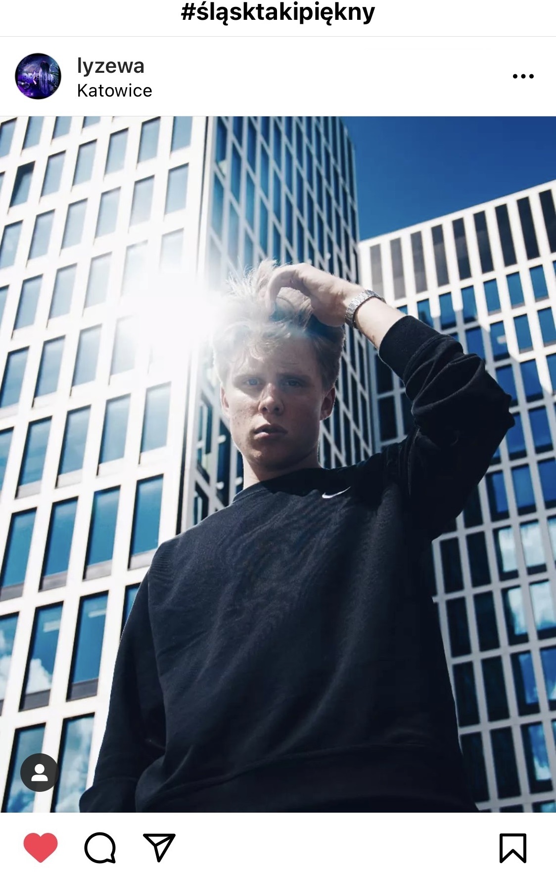 Chłopak w czarnej bluzie na tle szklanych wieżowców