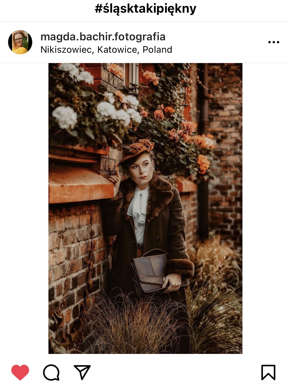 Dojrzała kobieta stojąca przy kamienicy wokół sielski klimat, kwiaty i trawa.