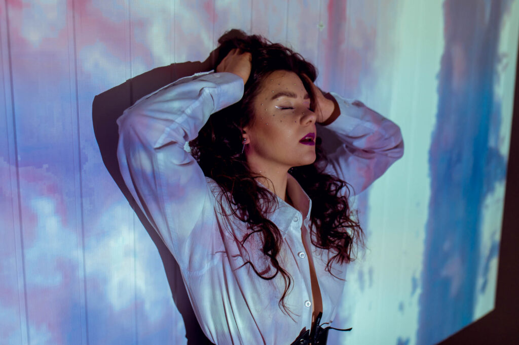 Kobieta opierająca się o kolorową ścianę