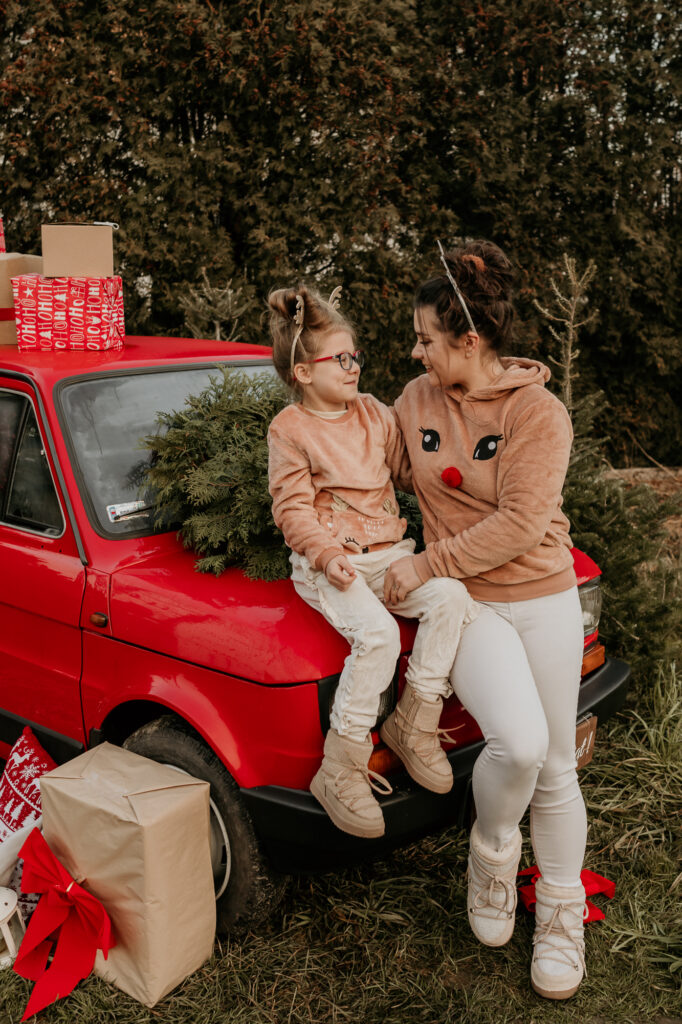 matka z córką siedzą na masce samochodu