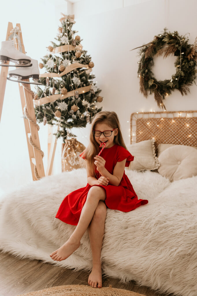 dziewczynka w czerwonej sukience na łóżku