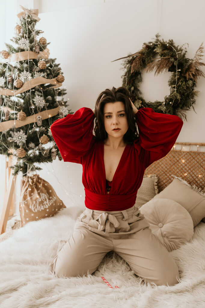 kobieta na łóżku w czerwonej bluzce