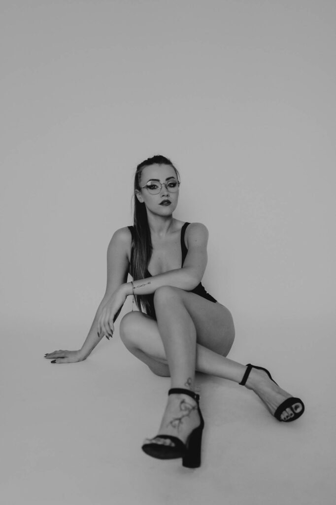 kobieta siedzi w szpilkach i body na podłodze