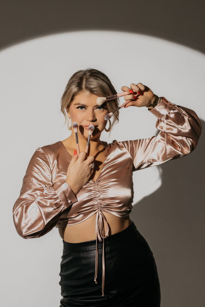 portret kobiety z pędzlami do makijażu