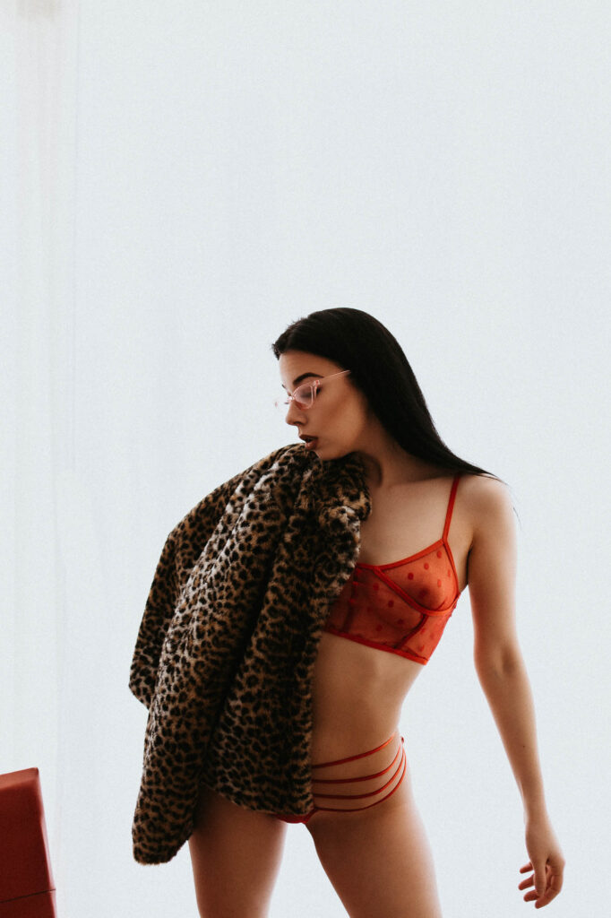 kobieta w czerwonym staniku na ramieniu ma futro w panterkę