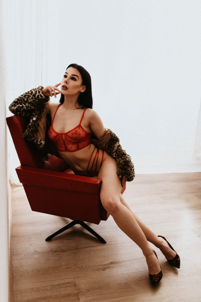 Kobieta w bieliźnie siedzi na czerwonym krześle