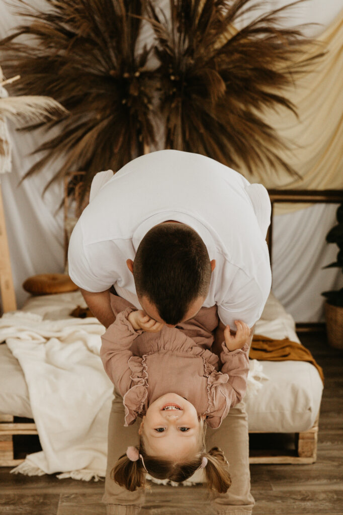 mężczyzna wygłupia się z córką, śmieją się