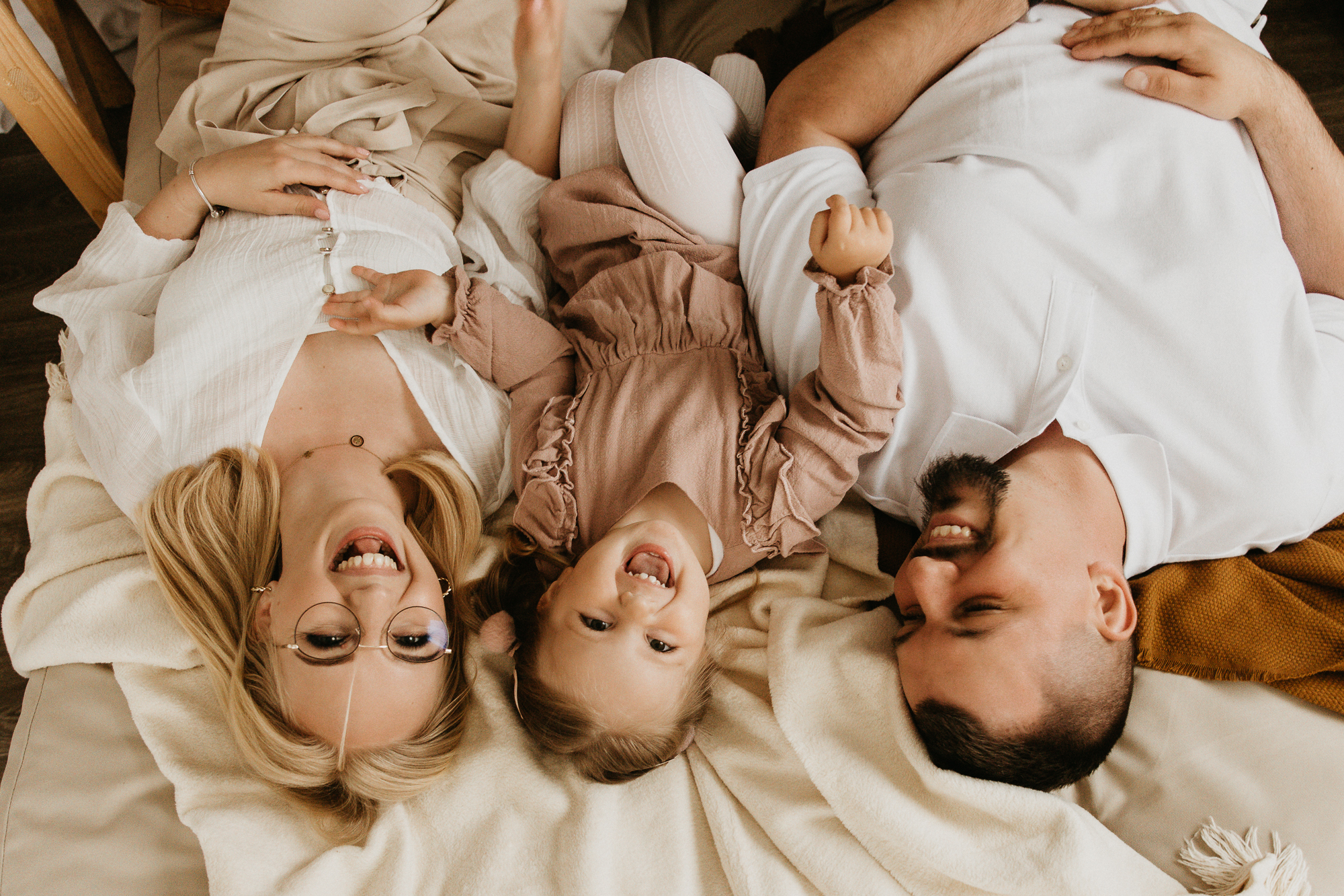 uśmiechnięta rodzina leży na łóżku