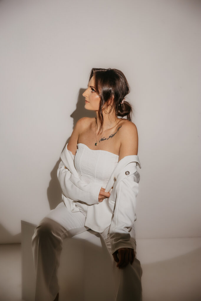 kobieta ubrana w bialy komplet, spogląda w lewo