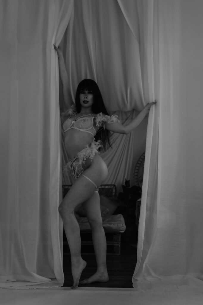 kobieta w stroju kąpielowym stoi w firanie