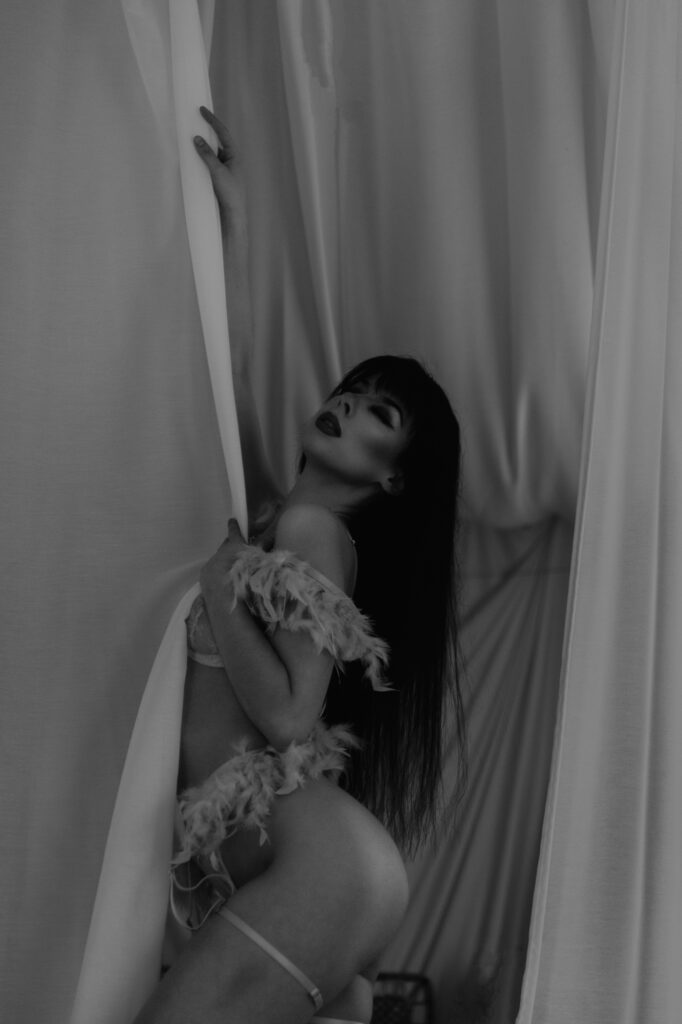 kobieta skąpo ubrana stoi przy zasłonie